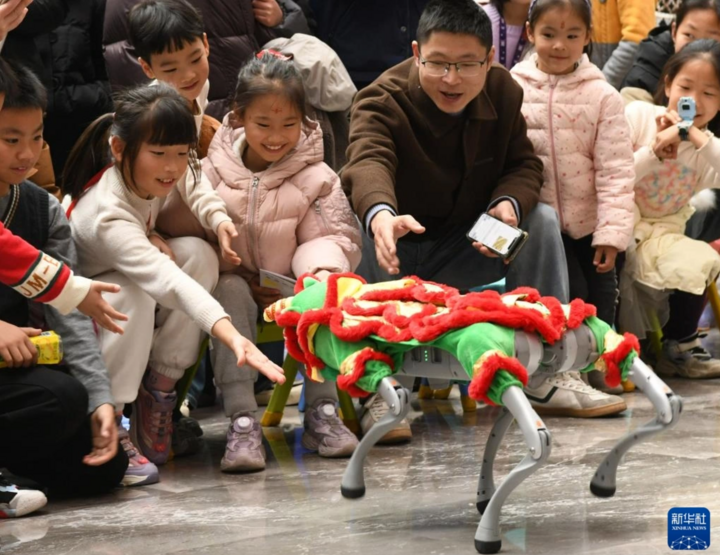 Các em nhỏ tương tác với chó robot tại thành phố Kim Hoa, tỉnh Chiết Giang. (Ảnh: Tân Hoa xã)