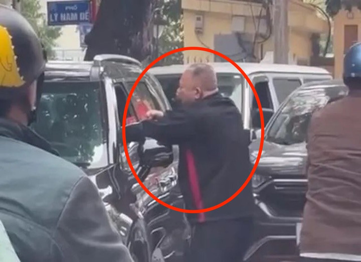 Người đàn ông liên tiếp đấm tài xế ngồi trên ô tô. (Ảnh chụp màn hình)