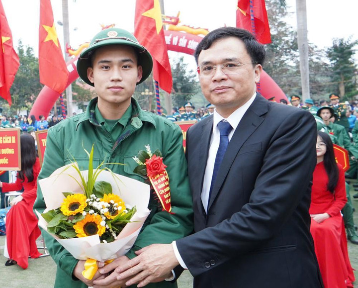 Ông Đặng Văn Tuấn, Chủ tịch UBND thị xã Quế Võ, tặng hoa động viên tân binh.