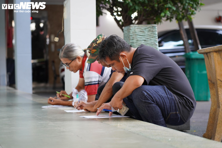 Người dân ngồi bệt trên nền nhà hoàn thiện thông tin cá nhân để chờ lấy số cấp đổi GPLX.