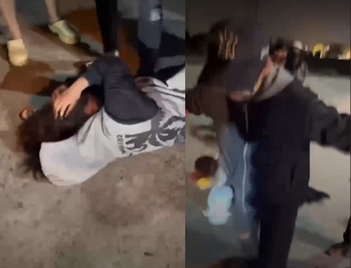 Nạn nhân bị đánh hội đồng, chỉ biết ôm đầu tránh né các cú đạp. (Ảnh cắt từ clip).