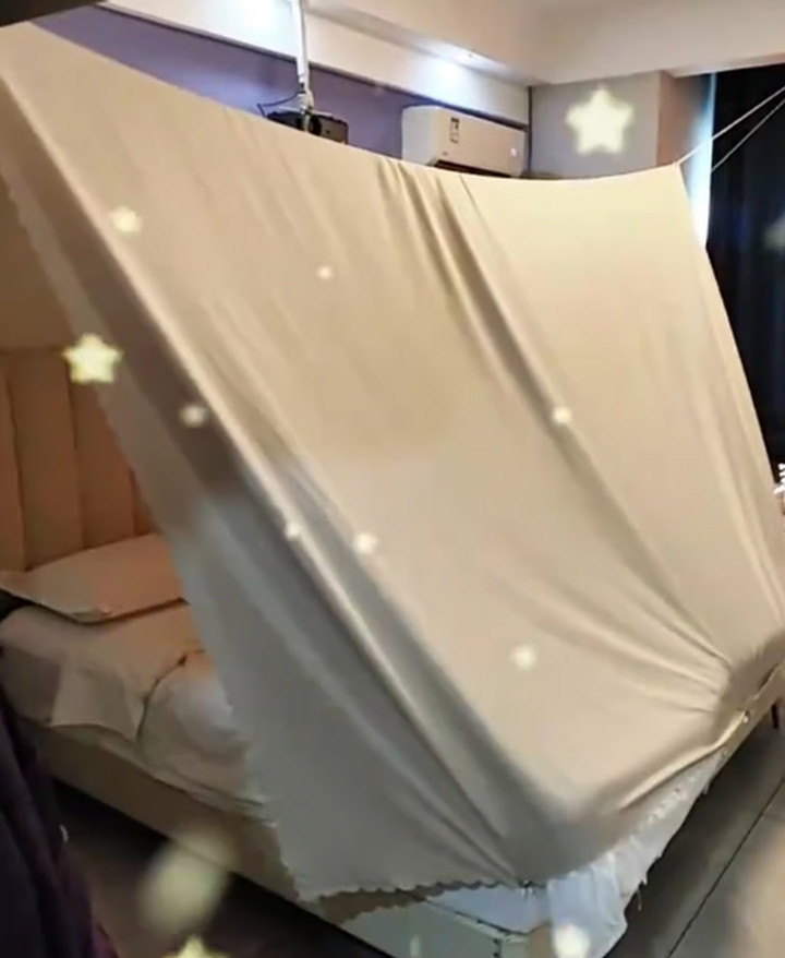 Dang dùng tấm bọc đồ đạc chống bụi để làm lều khi lưu trú tại khách sạn. (Ảnh: Baidu)