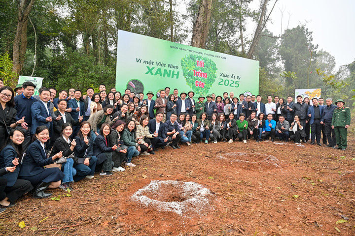 Các đại biểu chụp ảnh lưu niệm tại vườn cây "Đời đời nhớ ơn Bác Hồ" của Vietcombank tại khu di tích trước khi trồng cây.