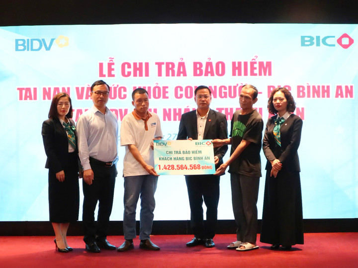 Đại diện BIC và BIDV Thanh Xuân trao tiền bảo hiểm cho đại diện gia đình khách hàng.
