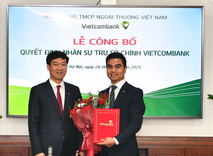 Ông Vũ Quang Đông - Phó Giám đốc Khối phụ trách Khối Vốn và Thị trường Vietcombank (bên trái) trao Quyết định bổ nhiệm và tặng hoa chúc mừng ông Nguyễn Hữu Tùng – tân Phó Giám đốc Ban Giao dịch thị trường tài chính toàn cầu Vietcombank.