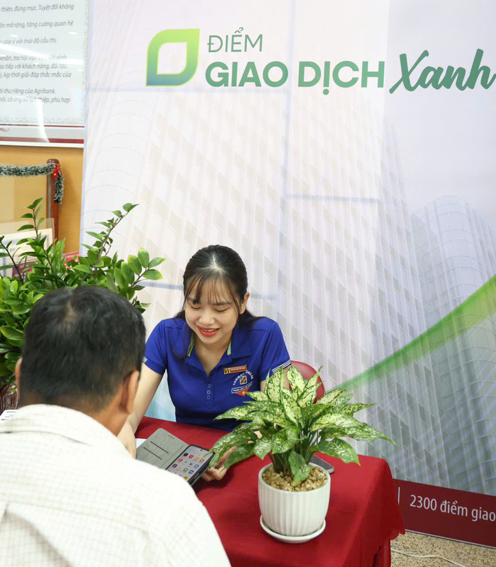Cán bộ Agribank đang hướng dẫn khách hàng trải nghiệm các dịch vụ số của Agribank.