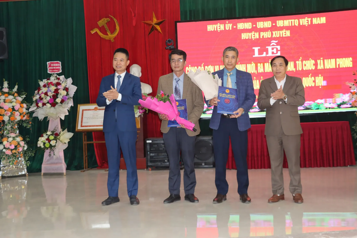 Lãnh đạo huyện Phú Xuyên trao quyết định và tặng hoa chúc mừng xã Nam Phong.