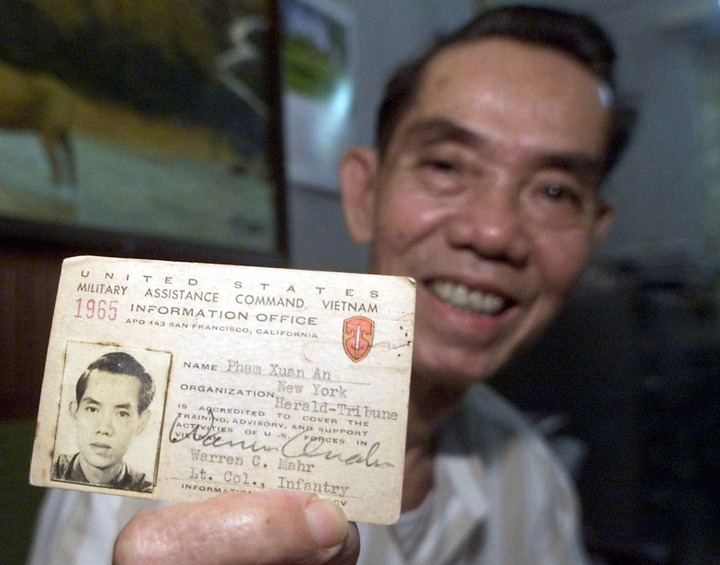 Ông Phạm Xuân Ẩn giơ thẻ báo chí năm 1965 tại nhà riêng ở thành phố Hồ Chí Minh, Việt Nam, năm 2000. (Ảnh: Charles Dharapak/AP)