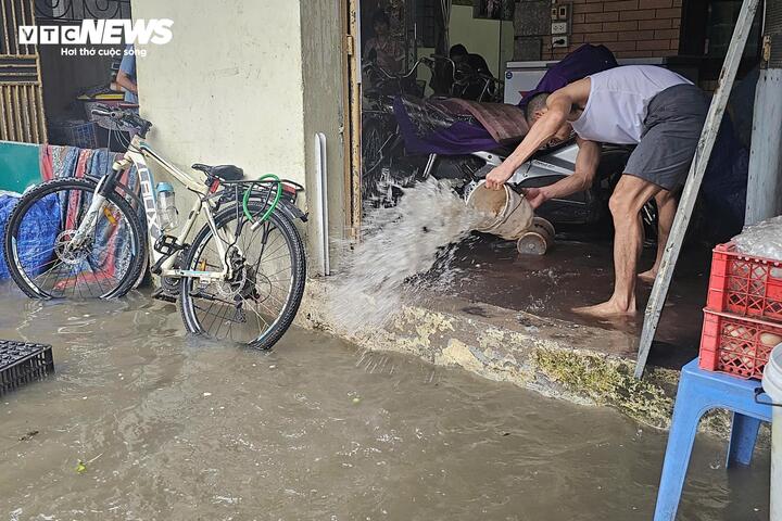Người dân phải dùng xô chậu múc nước ra khỏi nhà, kê cao đồ đạc để hạn chế thiệt hại.