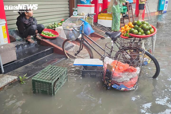 “Tôi mới ra chợ được hơn chục phút thì nước bắt đầu dâng cao. Lúc đầu còn cố đứng bán, nhưng nước ngập nhanh quá nên ngồi đây chờ nước rút vậy
