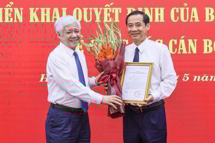 Chủ tịch Ủy ban Trung ương MTTQ Việt Nam Đỗ Văn Chiến trao quyết định và tặng hoa chúc mừng ông Nguyễn Thái Học. (Ảnh: Quang Vinh)