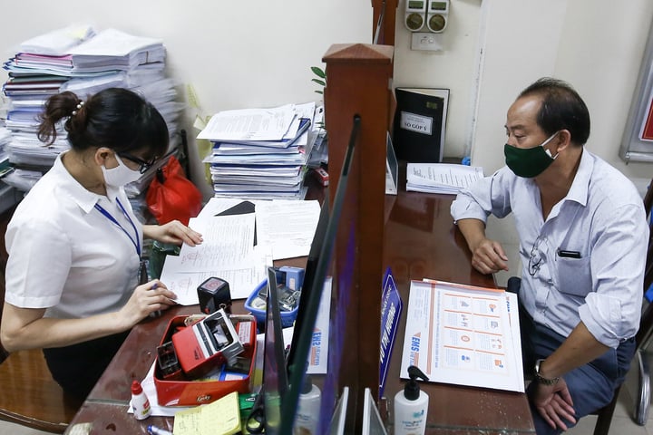 Công chức TP Hà Nội hỗ trợ người dân giải quyết thủ tục hành chính. (Ảnh: Hữu Thắng)