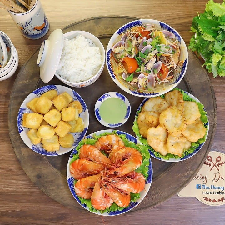 Bữa ăn này có tôm sú hấp nước dừa, chả mực, đậu phụ rán, canh chua ngao nấu dứa.