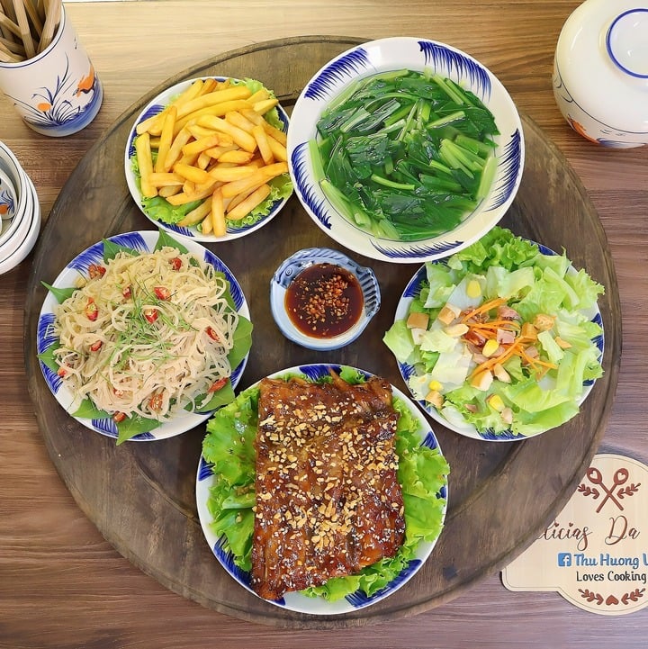 Thực đơn gồm các món sườn nướng sốt mắm tỏi, nem bì thính, salad xà lách trộn sốt mè rang, khoai tây chiên, canh rau cải ngọt.