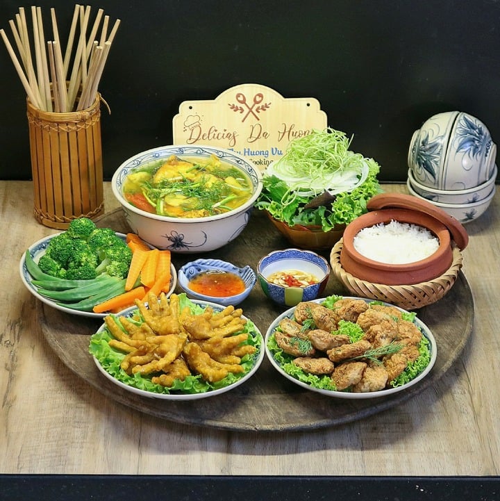Mâm cơm này có món chả cá, chân gà chiên giòn, canh cá nấu chua, rau củ luộc.