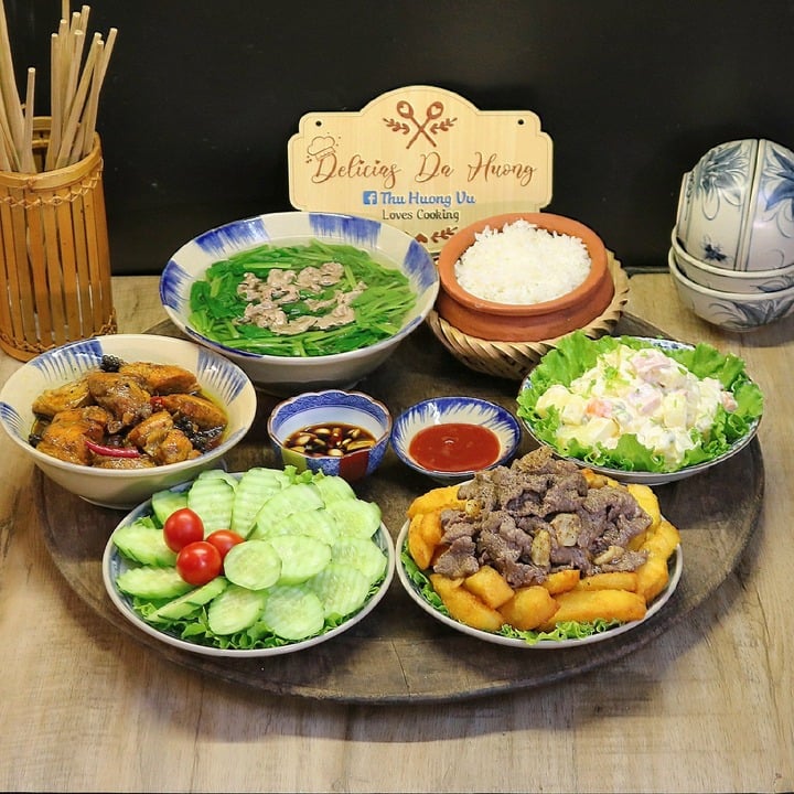 Thực đơn gồm món thịt bò xào khoai tây, cá hồi kho tiêu, canh cải xanh, salad.