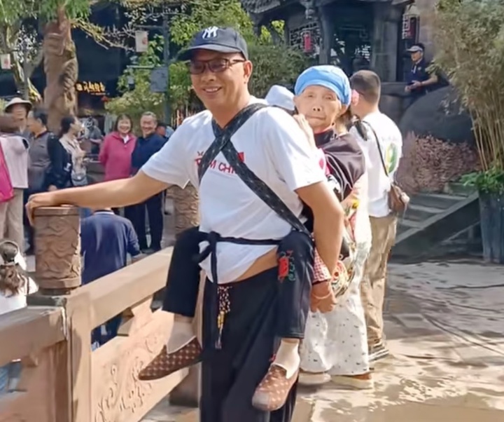 Ông Chai Wanbin địu người mẹ bị liệt của anh trong một chuyến đi. (Ảnh: Douyin)