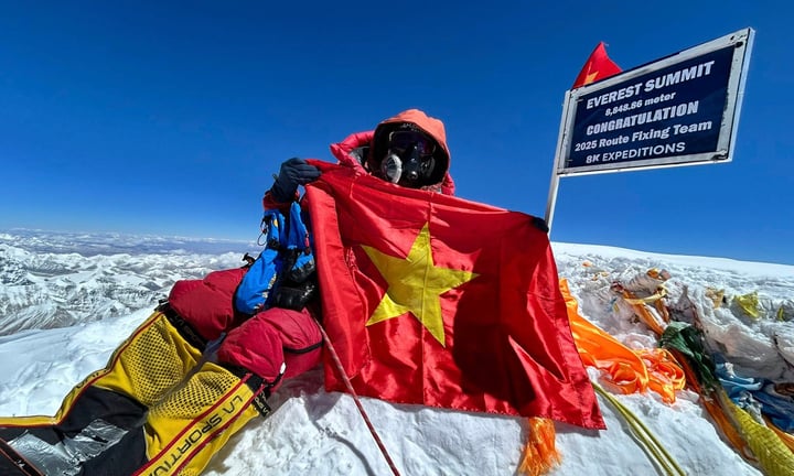 Nhà leo núi Nguyễn Mạnh Duy chụp ảnh trên đỉnh Everest, cạnh cột mốc do 8K Expeditions đánh dấu.