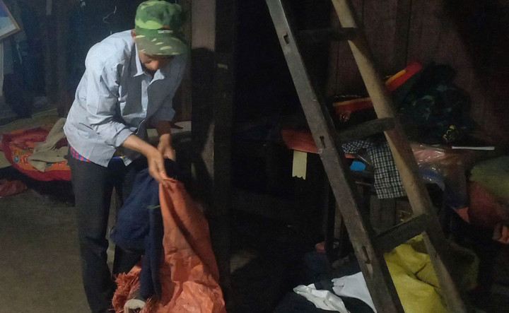 Anh Phàn Phủ Khẩu gấp những bộ quần áo, di vật duy nhất còn sót lại để chôn cùng người thân trong tang lễ.