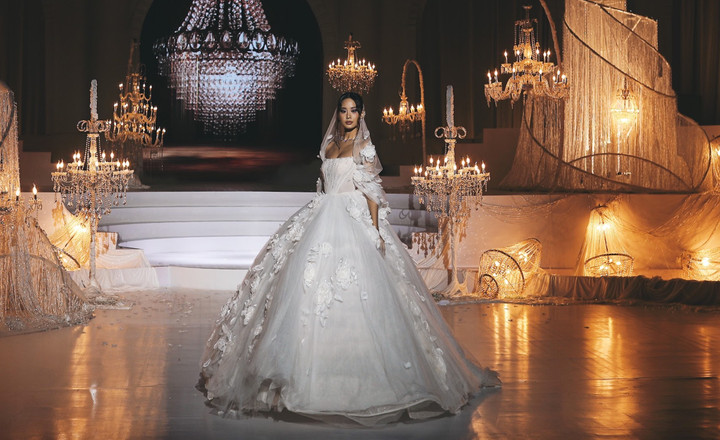 Mở đầu show diễn, hoa hậu Bảo Ngọc mang đến hình ảnh nàng công chúa trong chiếc đầm bồng bềnh đính hoa 3D, khăn voan trắng dài.