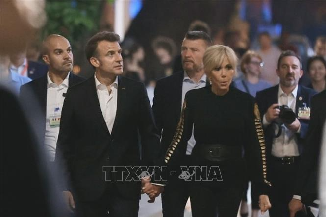 Tổng thống Pháp Emmanuel Macron và Phu nhân nắm tay nhau cùng dạo phố cổ Hà Nội. (Ảnh: TTXVN)
