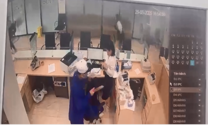 Tên cướp cầm dao uy hiếp nhân viên ngân hàng để lấy tiền.