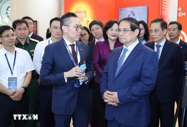 Thủ tướng Phạm Minh Chính tham quan trưng bày sản phẩm dịch vụ, ứng dụng chuyển đổi số trong hoạt động ngân hàng. (Ảnh: TTXVN)
