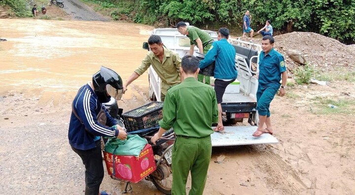 Lực lượng chức năng địa phương huy động phương tiện đến giúp đỡ người dân đảm bảo an toàn đi qua các cầu tràn