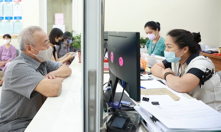 Công chức phường ở Hà Nội hỗ trợ người dân giải quyết thủ tục hành chính.