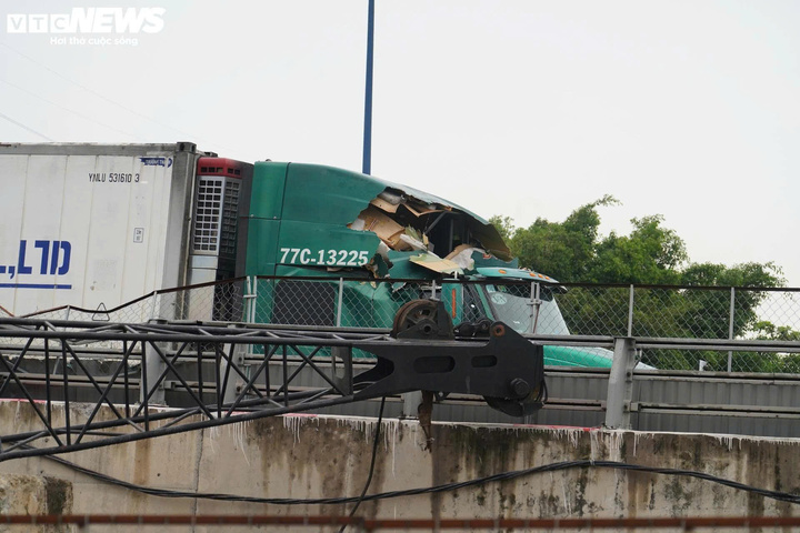 Xe container bị giàn cẩu đè trúng, hư hỏng nặng phần đầu xe. (Ảnh: L. Ý)