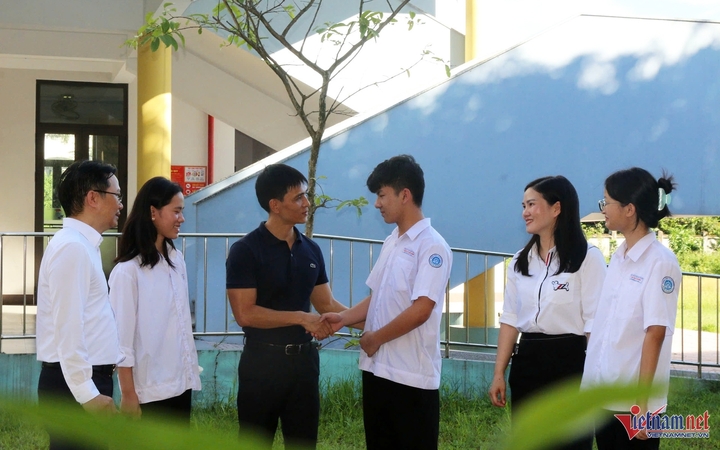 Teachers at Le Van Thiem Secondary School congratulate Tuan Dung on his excellent exam results. (Photo: Dau Tinh)