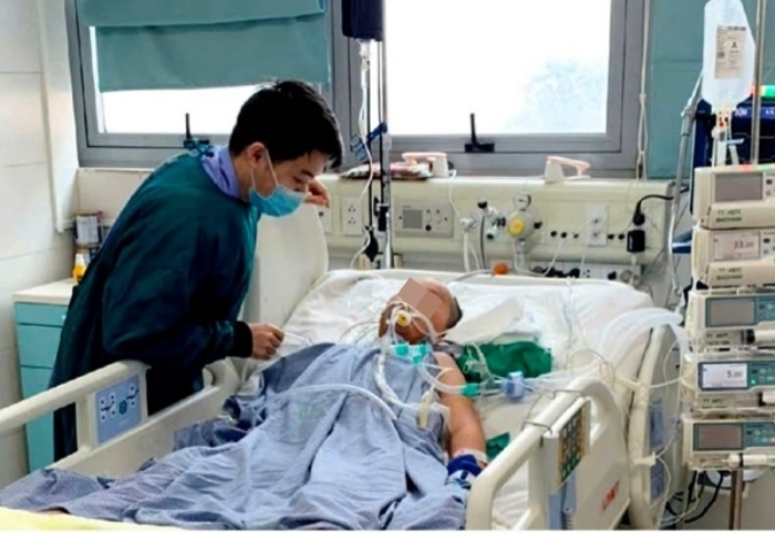 Anh Nguyễn Việt Hà – bố của Nguyên túc trực bên giường bệnh của con trai. (Ảnh: Nguyên Hà)