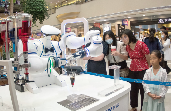 Khách tham quan đang tìm hiểu về Robot hoạt động tại triển lãm công nghệ. (Nguồn: Internet)