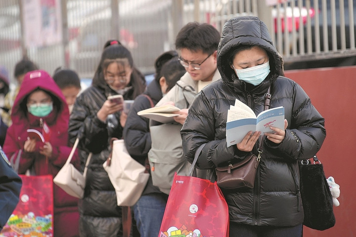 Các thí sinh tranh thủ xem lại tài liệu ôn tập lần cuối trước khi bước vào điểm thi kỳ thi công chức quốc gia tại Thái Nguyên, tỉnh Sơn Tây, Trung Quốc (ngày 26/11/2023). (Ảnh: China News Service)