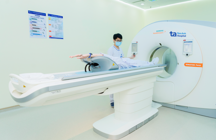 Kỹ thuật viên hướng dẫn người bệnh nằm đúng tư thế trước khi khởi động “siêu máy CT” hơn 100.000 lát cắt. (Ảnh: BVĐK Tâm Anh)