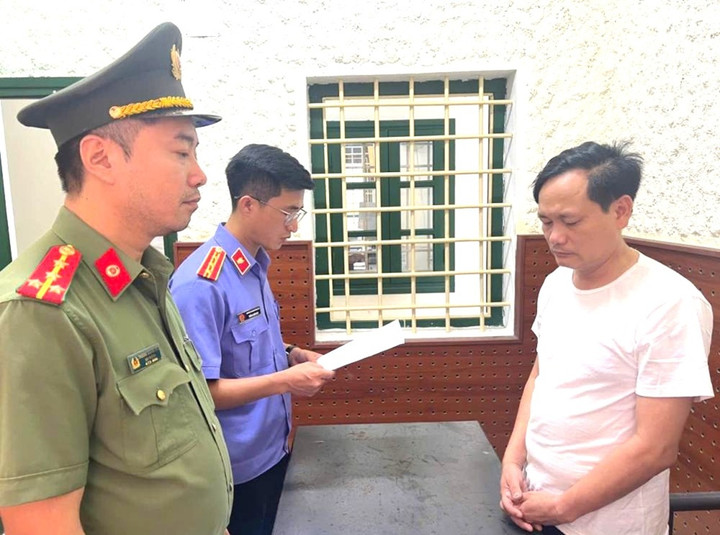 Lực lượng chức năng đọc quyết định khởi tố bị can Lê Hữu Ngọc. (Ảnh: Công an Hà Tĩnh)