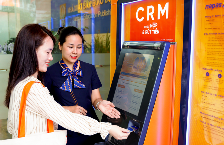 Giao dịch viên SHB hướng dẫn khách hàng sử dụng máy CRM.