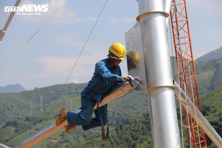 Người công nhân trèo lên ôm thân cột điện trong điều kiện nắng nóng, nhiệt độ hơn 40ºC.