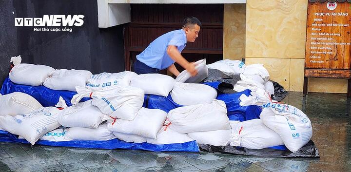 Trong sáng 21/7, người dân tranh thủ gia cố đề phòng nước tràn vào nhà khi bão đổ bộ gây mưa lớn. (Ảnh: Tiến Thắng)