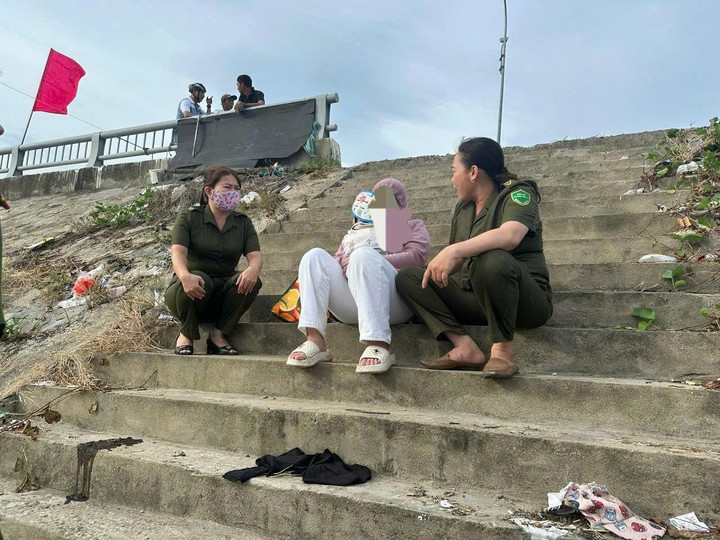 Lực lượng chức năng vận động, khuyên nhủ người phụ nữ từ bỏ ý định tự tử. (Ảnh: C.A)