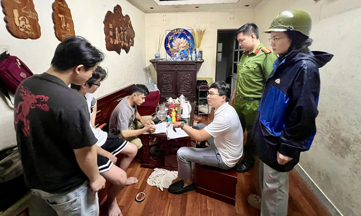 Tổ công tác phường Giảng Võ vận động người dân nhà G6A di chuyển để tránh bão. (Ảnh: Duy Minh)