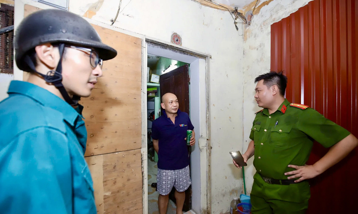 Tổ công tác vận động, yêu cầu người dân di dời tới cơ sở lưu trú. (Ảnh: Duy Minh)