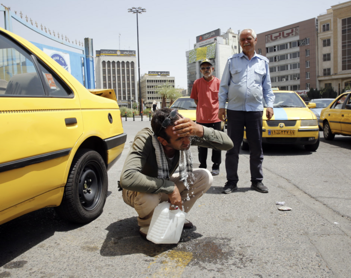 Tài xế taxi cố gắng làm mát khi nhiệt độ tại thủ đô Tehran vẫn ở mức cao. (Ảnh: EPA)