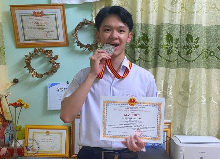 Đoàn Thanh Tùng bên "bộ sưu tập" thành tích học tập của mình. (Ảnh: NVCC)