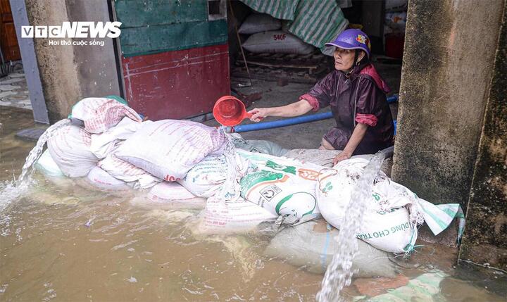 Người dân Thanh Hoá tát nước tràn vào nhà trong đợt mưa lớn ngày 22/7. (Ảnh: Viên Minh)
