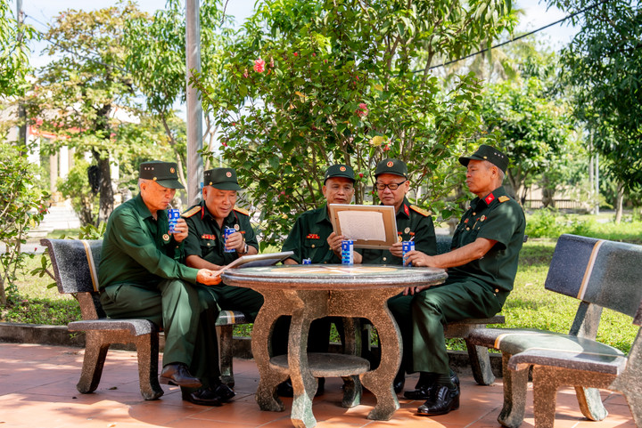 Các bác cựu chiến binh chăm chú đọc những dòng chữ nhỏ, được các em gửi kèm trong mỗi bức tranh. (Ảnh: Duy Cường).