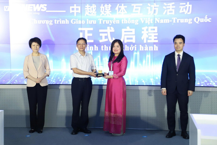 Đại diện hai bên trao quà lưu niệm cho nhau.