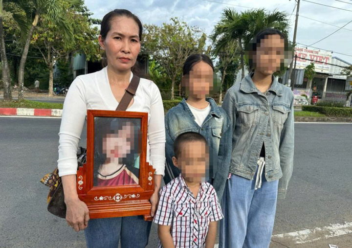 Bà Hiền ôm di ảnh bé Trân, bên cạnh là ba người con (em của Trân), sau buổi làm việc với cơ quan điều tra Công an tỉnh Vĩnh Long. (Ảnh: H.T.)