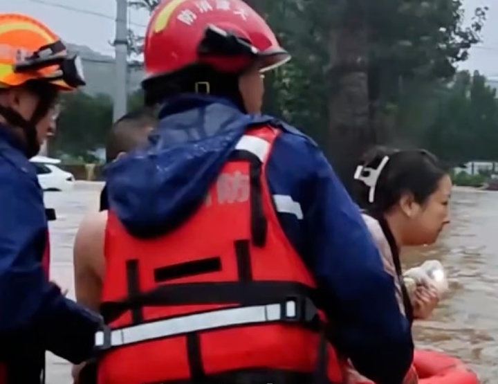 Lưu khăng khăng nhờ đội cứu hộ lũ lụt cứu vợ trước. (Ảnh: Handout)