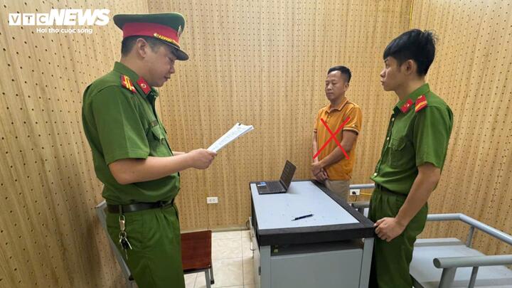 Cơ quan CSĐT Công an tỉnh Sơn La thi hành các quyết định đối với kẻ cầm đầu đường dây Đinh Văn Tuấn (áo cam). (Ảnh: CACC)